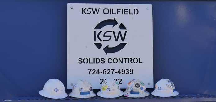 Hard hats in front of KSW Oilfield sign